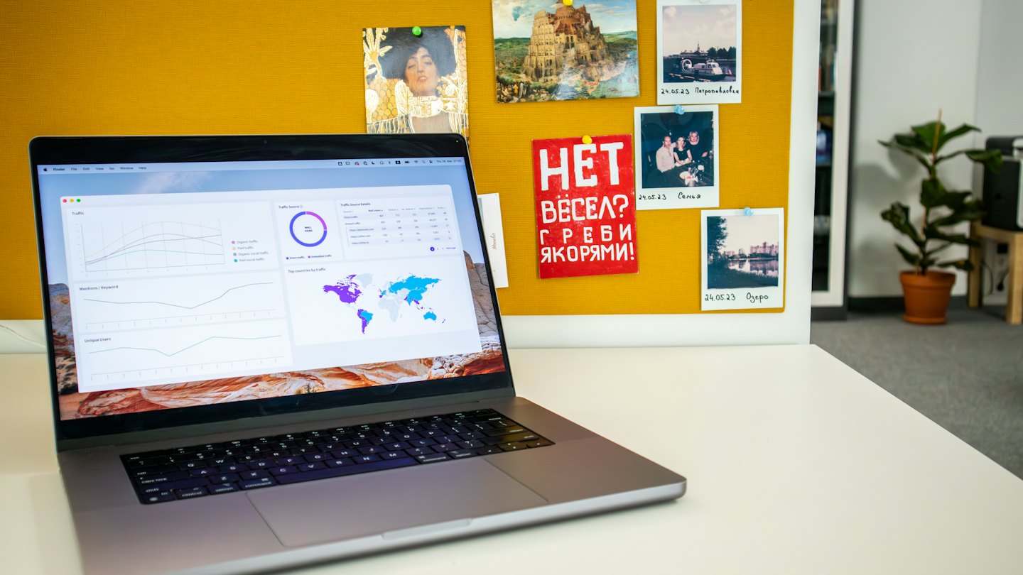 Laptop mit Datenanalyse-Dashboard auf einem weißen Schreibtisch.